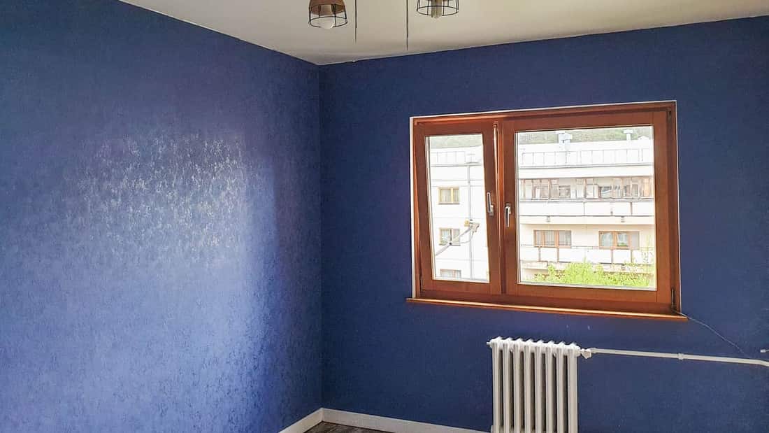 Frisch gestaltete blaue Wand mit Holzfenster und Heizkörper — Beispielfoto